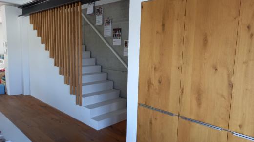 Holzbalken als Treppengeländer und Einbauschrank